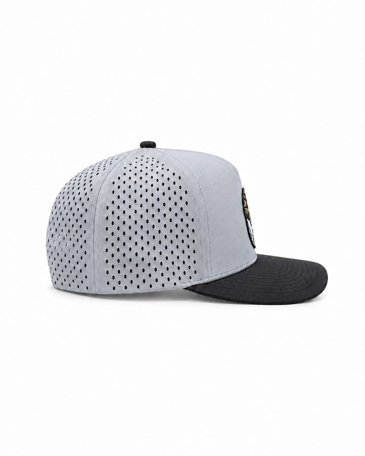 Peaky snapback hat in grey with a black brim and a perforated side panel, side view
